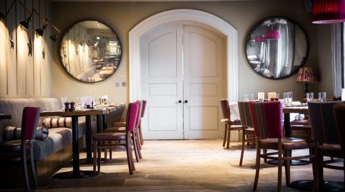 a dining room with tables and chairs and two mirrors at The Grosvenor Arms in Shaftesbury