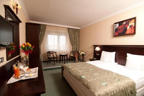 Un pat sau paturi într-o cameră la Hotel Rapsodia City Center
