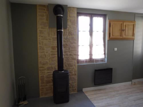 - un poêle noir dans une chambre avec fenêtre dans l'établissement GITE 