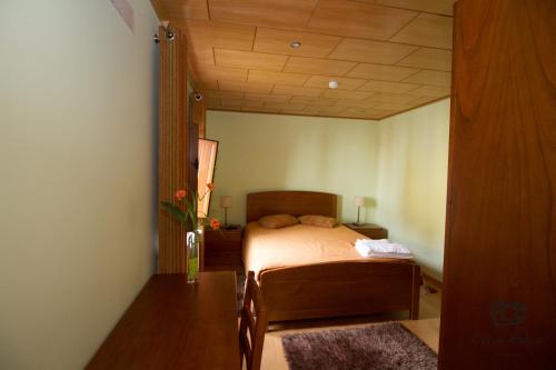 a bedroom with a bed and a wooden ceiling at Casa do Telheiro in Sabugueiro