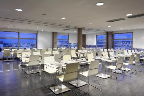 a conference room with tables and chairs and windows at Eurostars Arenas de Pinto in Pinto