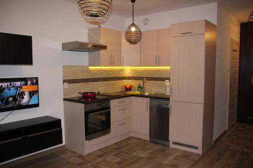 La cuisine est équipée de placards blancs et d'un four avec plaques de cuisson. dans l'établissement Apartment Wielicka Cracow, à Cracovie