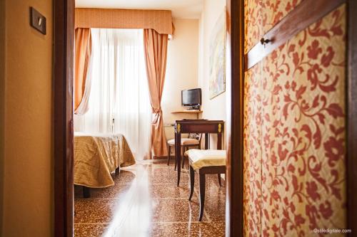 a room with a bed and a table and a window at Hotel La Pace in Pisa