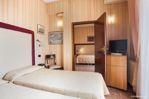 um quarto de hotel com duas camas e uma televisão em Hotel La Pace em Pisa