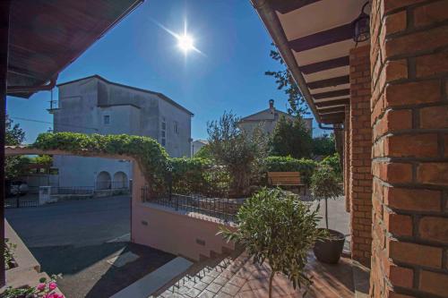 a brick building with a fence with plants on it at Apartments Bego Spa & Wellness in Crikvenica