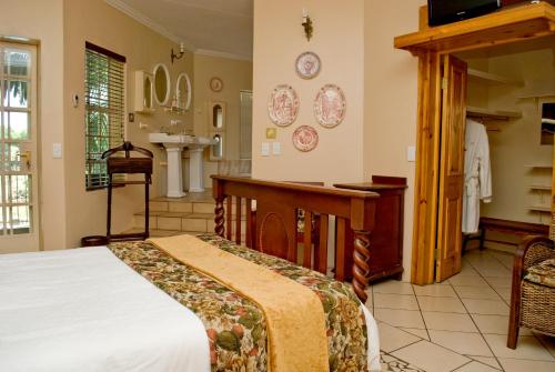 a bedroom with a bed and a sink at Belvedere-on-River in Malelane