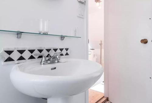 a white bathroom with a sink and a shower at L'Hotel Particulier Griffintown in Montréal