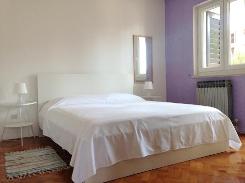 1 dormitorio con cama blanca y ventana en Accommodation Vitalio, en Umag