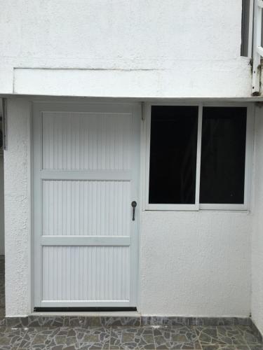 a white garage door with two windows on a building at Tropical Dreams in San Andrés
