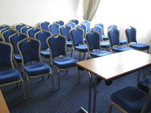 a row of chairs in a room with blue chairs at Hotel Rapsodia City Center in Botoşani