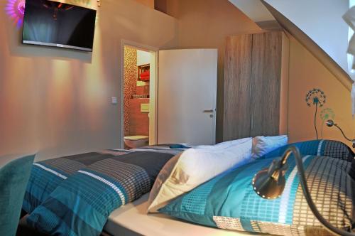 um quarto com uma cama e uma televisão na parede em Frankfurt Bed & Breakfast em Frankfurt