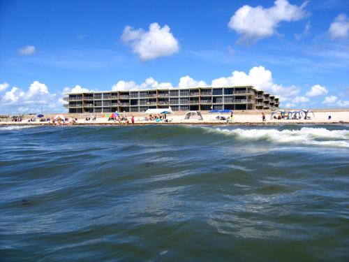 a hotel on the beach and the ocean with a building at Island House BeachFront Condo Hotel in Corpus Christi