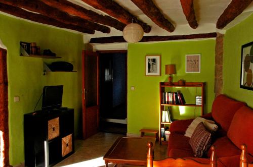 - un salon avec des murs verts et un canapé rouge dans l'établissement Casa Lugaré, à Ayerbe