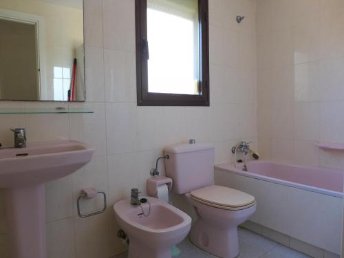 a bathroom with a toilet and a sink and a tub at Rentalmar Amanecer in Miami Platja