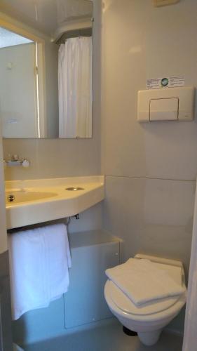 a bathroom with a toilet and a sink and a mirror at Premiere Classe La Rochelle Sud - Angoulins in Angoulins