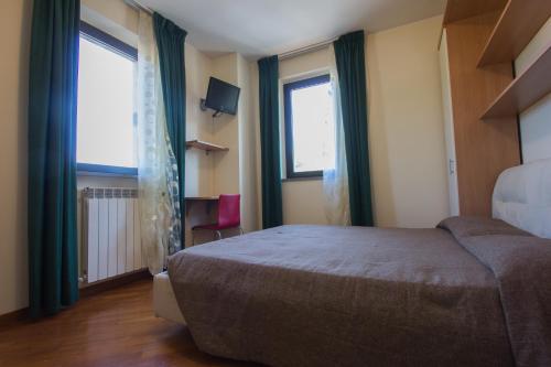 a bedroom with a bed and two large windows at Antica Pieve in Filattiera