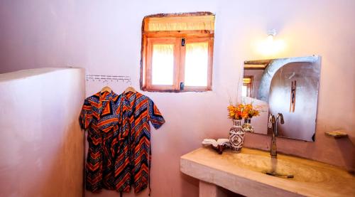 a bathroom with a sink and a mirror at Wild Tracks Overland Camp in Kasese