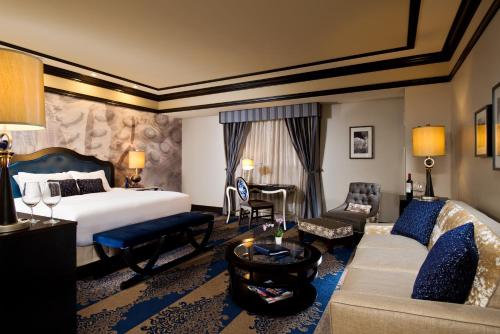 a hotel room with a bed and a couch at Saratoga Casino Hotel in Saratoga Springs