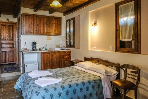 małą sypialnię z łóżkiem i kuchnią w obiekcie Kastania Gi w mieście Palaios Panteleimon