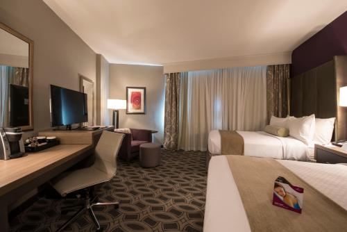 a hotel room with two beds and a desk with a computer at Crowne Plaza Saddle Brook by IHG in Saddle Brook