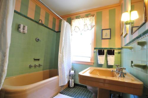 a bathroom with a tub and a sink and a bath tub at The Brewster Inn in Dexter