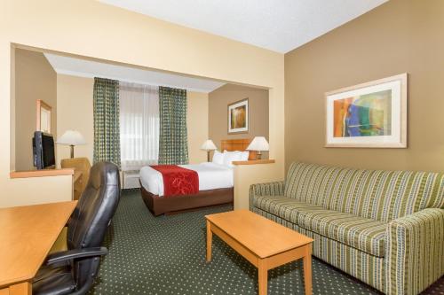 a hotel room with a couch and a bed at Baymont by Wyndham Billings in Billings