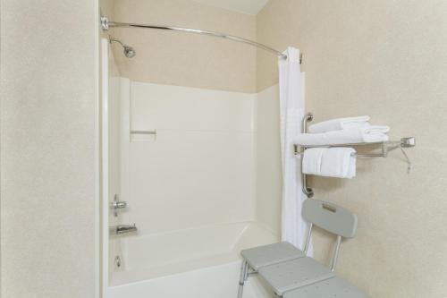 a bathroom with a shower with a toilet and towels at Baymont by Wyndham Billings in Billings