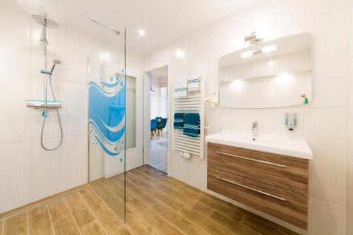 ein Bad mit einem Waschbecken und einer Glasdusche in der Unterkunft Haus Zobler in Binz