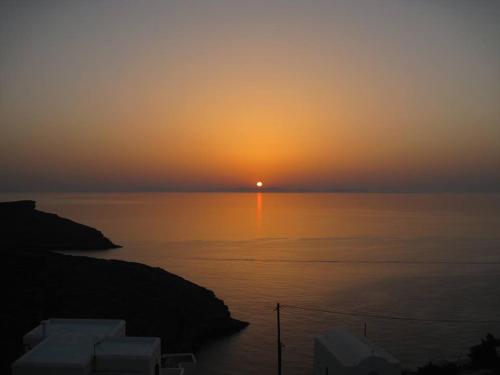 a sunset over the water with the sun in the distance at Darsi suites Kythnos in Kithnos