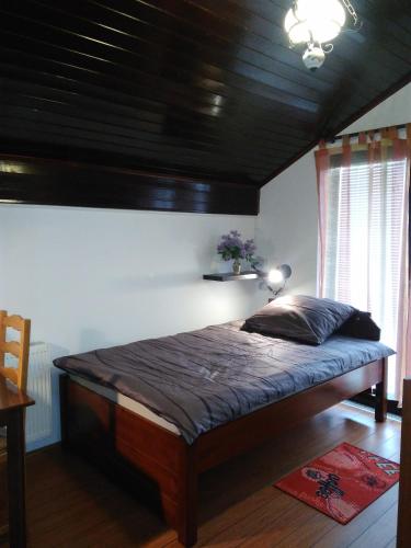 a bedroom with a large bed with a wooden ceiling at Rooms Hazler in Slunj