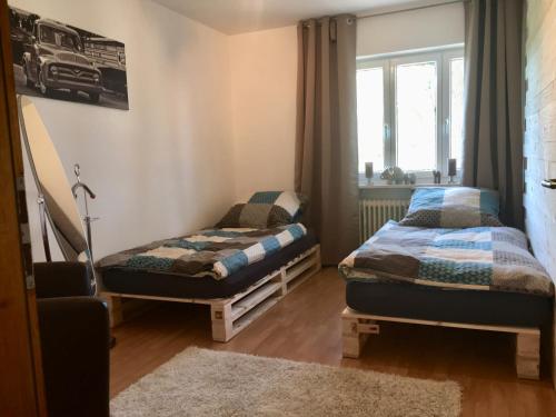 1 Schlafzimmer mit 2 Einzelbetten und einem Fenster in der Unterkunft Ferienwohnung Döllinger Messe Fränkisches Seenland in Schwabach