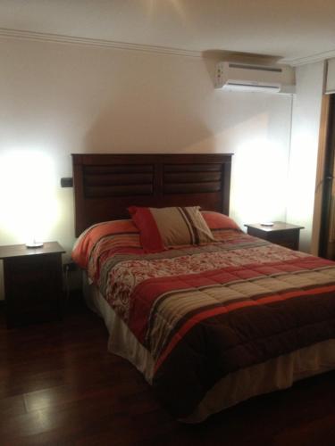 a bedroom with a large bed with two lamps at Barceló Suites Providencia I in Santiago