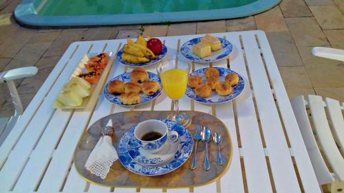 a table with plates of food and a cup of orange juice at Hospedaria Conceitual in Florianópolis