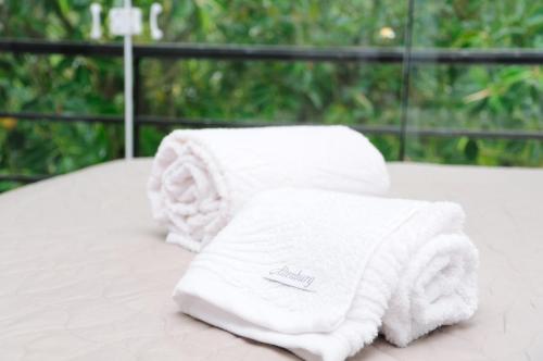 two white towels sitting on top of a table at Flat Beira Rio in Ribeira