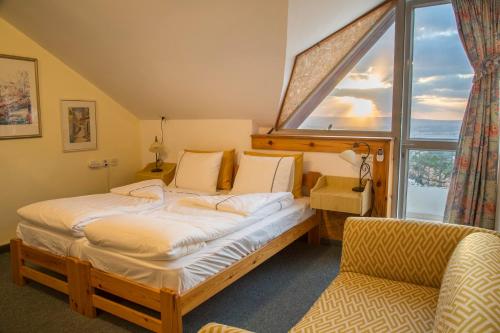 a bedroom with a bed and a chair and a window at Yaffe Bagilboa in Gan Ner