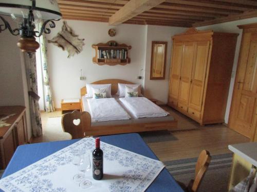 een slaapkamer met een bed en een tafel met een fles erop bij Ferienwohnung Vierthaler in Gosau