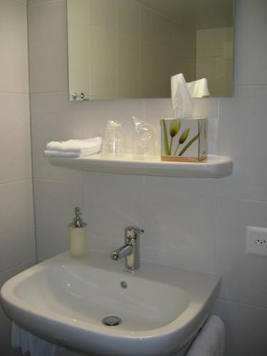 a white sink in a bathroom with a mirror at Auberge du Prévoux in Le Locle