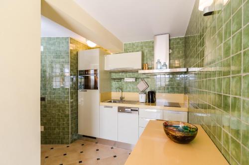 a kitchen with white cabinets and a bowl on a table at Studio apartment Antica in Čilipi