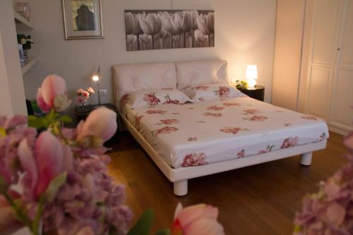 a bedroom with a bed with pink flowers on it at Il Giardino delle Rose in Santa Maria Nuova