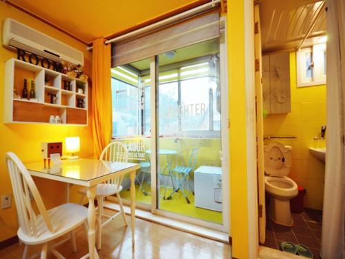 a yellow bathroom with a table and a toilet at Han River Residence & Guesthouse in Seoul