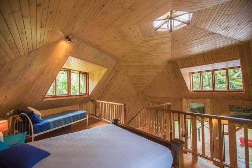 ケープ・トリビュレーションにあるCape Tribulation Holiday Houseの木造キャビン内のベッド2台が備わる部屋