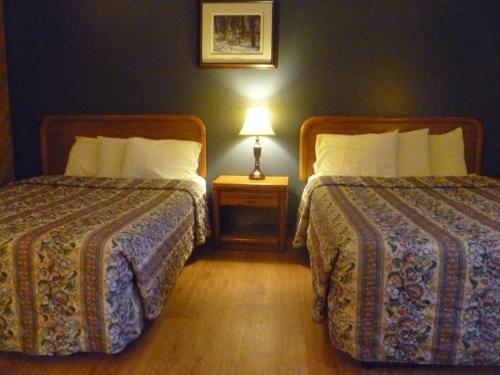 a hotel room with two beds and a lamp at Timber Inn Motel in Phillips