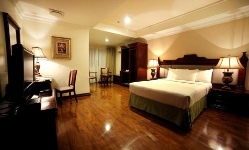Habitación de hotel con cama y escritorio en Villa Caceres Hotel, en Naga