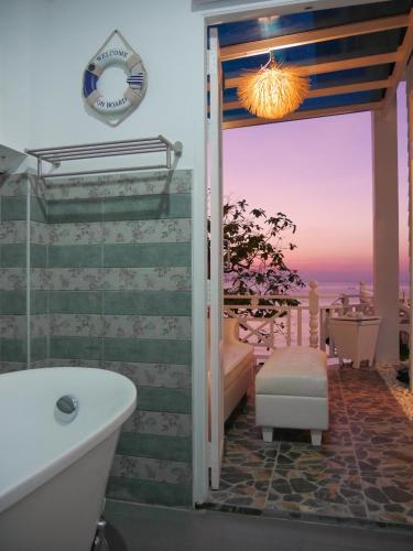 a bathroom with a tub and a view of the ocean at DD Hut Koh Tao in Koh Tao