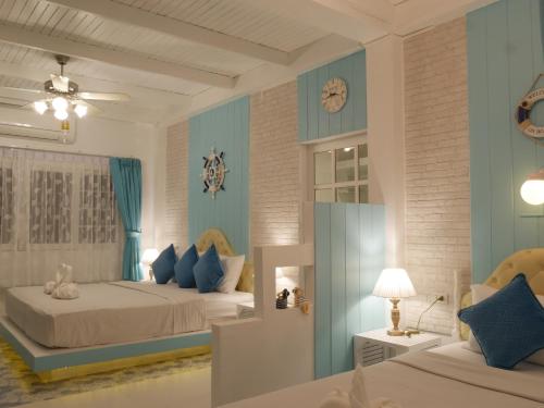 a bedroom with two beds and a clock on the wall at DD Hut Koh Tao in Koh Tao