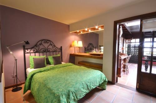 a bedroom with a bed with a green comforter at Casa Teiga in Tahiche
