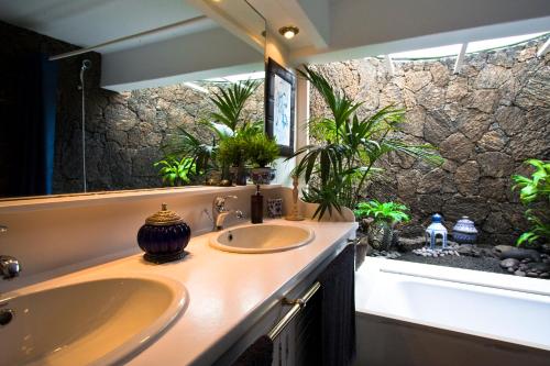 a bathroom with two sinks and a stone wall at Casa Teiga in Tahiche