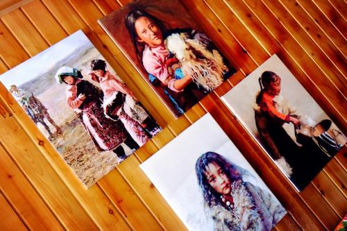 a group of pictures of people on a wall at Yi's Hostel in Shangri-La