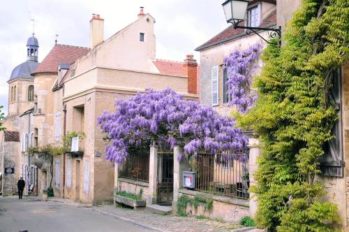 a wreath of purple flowers hanging from a building at Les Glycines Vézelay in Vézelay