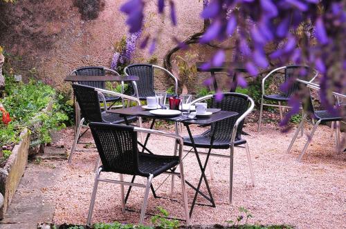 a group of tables and chairs in a garden at Les Glycines Vézelay in Vézelay